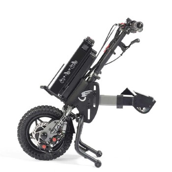 Handbike BATEC MINI 2 de color gris grafito plegado y anclado a una silla de ruedas manual, destacando su motor eléctrico.