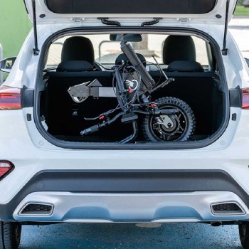 Handbike BATEC MINI 2 de color gris grafito plegado y anclado a una silla de ruedas manual, destacando su motor eléctrico.