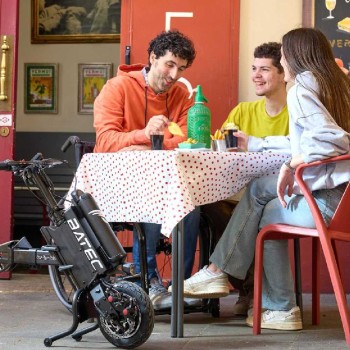 Handbike BATEC AIR de color negro acoplado a una silla de ruedas manual, destacando su diseño ultra compacto.