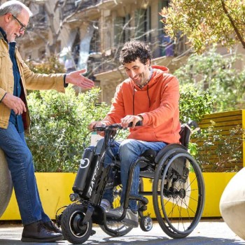 Handbike BATEC AIR de color negro acoplado a una silla de ruedas manual, destacando su diseño ultra compacto.