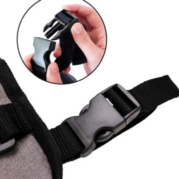 Mochila de almacenamiento negra instalada en el respaldo de una silla de ruedas con varios bolsillos visibles.