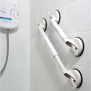 Barra de apoyo blanca con ventosas laterales y palancas de succión sobre azulejos de baño.