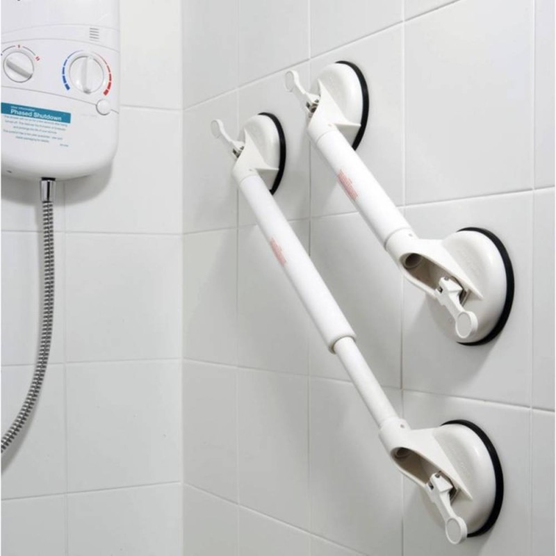 Barra de apoyo blanca con ventosas laterales y palancas de succión sobre azulejos de baño.